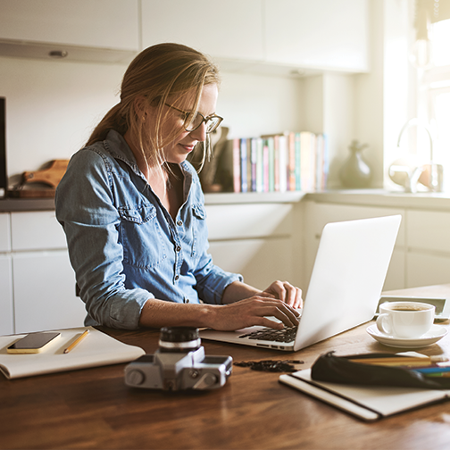 Women working on laptop on kitchen counter.