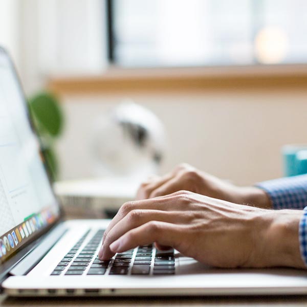 Person typing on laptop at office desk.