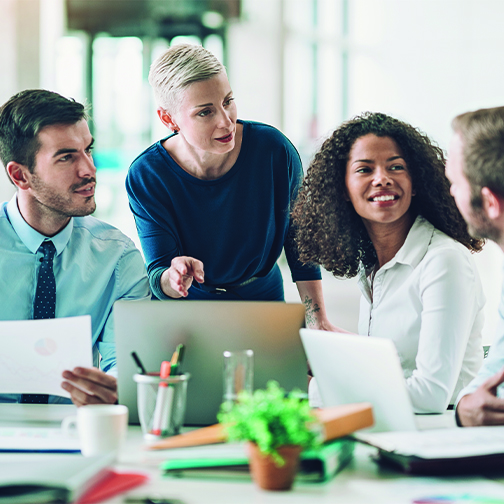 A group of office employees discussing a project around a table.