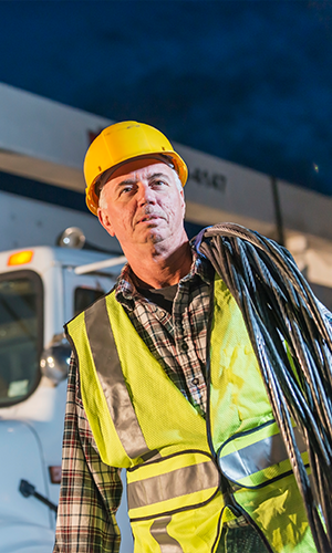 300x500-Thumbnail-Image-worker-in-hard-hat-and-safety-vest-with-fiber-spool-around-shoulder.png